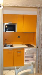 卡斯蒂里昂纳·德拉佩SUITE 225 Golf H PROMO SERVICE SRL的橙色的厨房配有水槽和冰箱