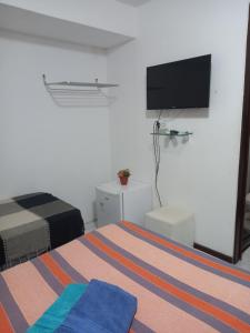 若昂佩索阿Pousada Aconchego do Tambaú的一间卧室配有一张床和一台平面电视