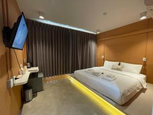 曼谷The Palette Bangkok Hotel的一间卧室配有一张床和一台平面电视