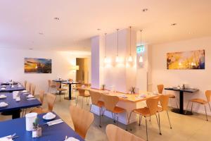 科隆Select Hotel Silence Garden Köln的一间带桌椅和绘画的用餐室