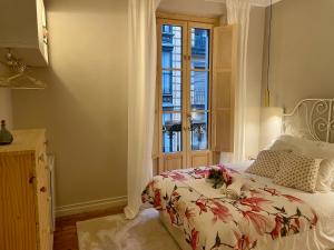 毕尔巴鄂Monappart Cristo Historic Apartment with Parking的一间卧室设有一张床和一个窗口