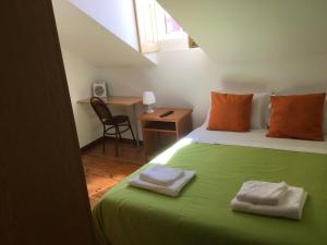 科英布拉杜阿尔特阿罗门托旅馆的一间卧室配有绿床和2条毛巾
