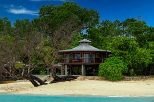 SaraotouExclusive Sunrise Eco Resort的海滩上树木和水的房子