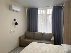 基辅Apartment Kiev Studio with city view的带沙发和窗户的客厅