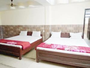 迪卡Hotel Parteek Residency Near Amrabati Park - Bypass Road Digha的两张睡床彼此相邻,位于一个房间里