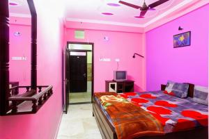 迪卡Hotel Parteek Residency Near Amrabati Park - Bypass Road Digha的粉红色的卧室配有床和电视