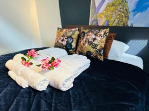布雷达Gilly's Gallery的床上的带鲜花的毛巾