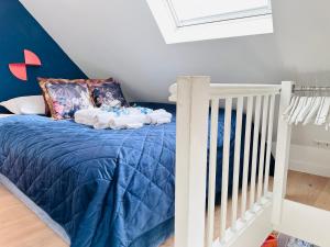 布雷达Gilly's Gallery的一间卧室配有一张蓝色床和一张婴儿床