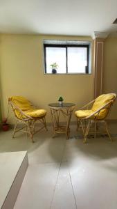 孟买OSTELO Mumbai Airport Hostel的一间设有两把椅子、一张桌子和一个窗户的房间