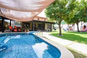 瓦兹特佩克Amazing family house in Oaxtepec Pool & Hot tub的游泳池上设有遮阳伞