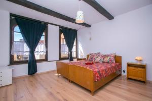 卡迪马里奥Chalet Cademario - Happy Rentals的一间卧室设有一张床和两个窗户。