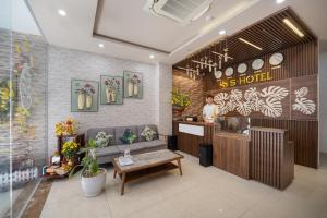 岘港S HOTEL BEACH ĐÀ NẴNG的站在商店柜台的女人