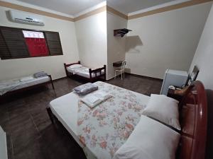 UbaranaHOTEL TABARANA的一间卧室配有一张床和一把椅子
