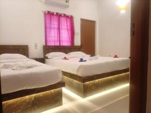 蓬蒂切里La Shashalia Luxury的金饰酒店客房内的两张床