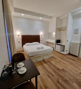 罗马Cuma Suites的酒店客房配有一张床铺和一张桌子。
