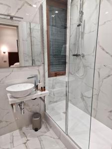 罗马Cuma Suites的带淋浴和盥洗盆的白色浴室