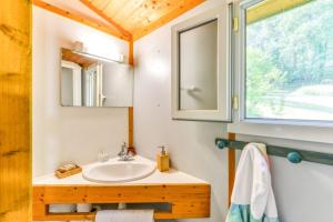 Aigues-VivesCamping LA SERRE的一间带水槽和镜子的浴室以及窗户。