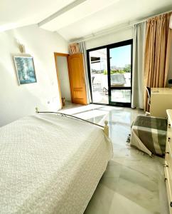 贝纳尔马德纳Penthouse Benalmadena Arroyo de la Miel centro的一间卧室设有一张床和一个大窗户