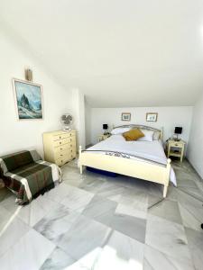 贝纳尔马德纳Penthouse Benalmadena Arroyo de la Miel centro的卧室设有一张大床,铺有瓷砖地板。