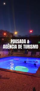 博尼图Bonito HI Hostel e Pousada的夜间游泳池,有“possada”和“argacionza de”的词句