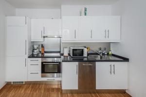 柏林Apartment Isabella的厨房配有白色橱柜和微波炉