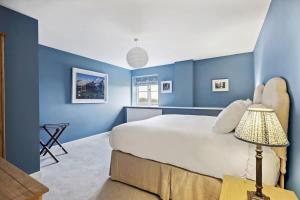 哈波罗集市Sophie's Barn - Hot Tub Packages Available的一间拥有蓝色墙壁的卧室和一张带灯的床