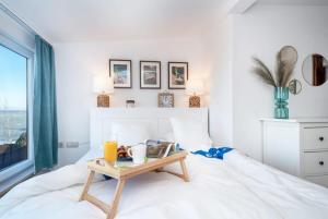 希欧福克Tóparti villa, közvetlen vízkapcsolattal的卧室配有一张白色的床和一张桌子