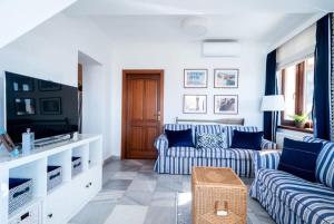希欧福克Tóparti villa, közvetlen vízkapcsolattal的客厅配有蓝色和白色的沙发以及电视。