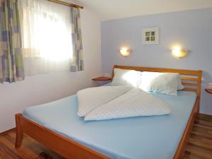 希帕赫Holiday Home Margit - MHO786 by Interhome的一间卧室配有一张蓝色的床和窗户