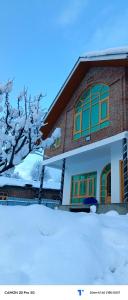 古尔马尔格The Himalayan Inn homestay的前面有雪的房子
