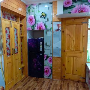 古尔马尔格The Himalayan Inn homestay的厨房配有冰箱和鲜花。