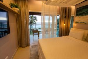 马利西亚斯Amora Hotel Maresias的一间卧室配有一张床,享有海景