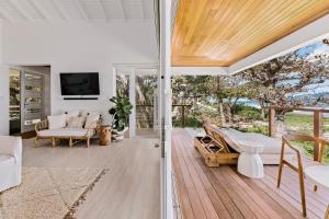 Tortola IslandLong Bay Beach Resort的开放式客厅配有白色家具和滑动玻璃门