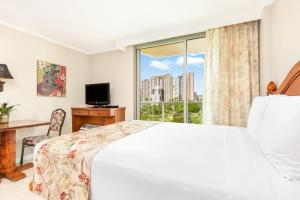 檀香山Luana Waikiki Hotel & Suites的一间卧室设有一张床和一个大窗户