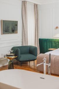 波尔多Hôtel Singulier Bordeaux的客厅配有绿色沙发和床。