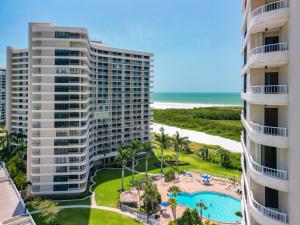 马可岛Beach Front Condo In Paradise Marco Island的享有两座高楼和一个游泳池的空中景致