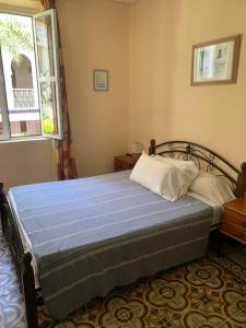 丹吉尔达而奥玛卡延旅馆的一间卧室配有一张带蓝色床单的床和窗户。