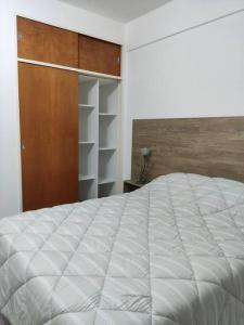 General SarmientoFortunati Departamentos的卧室配有一张白色大床和一个衣柜