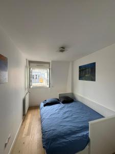 皮托Appartement moderne et agréable, idéalement placé pour JO 2024的一间白色客房内的蓝色床卧室