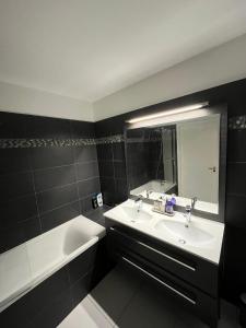皮托Appartement moderne et agréable, idéalement placé pour JO 2024的一间带水槽、浴缸和镜子的浴室