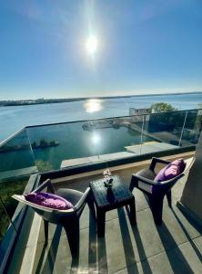 马马亚C&Y Solid Residence的阳台配有两把椅子和一张桌子,享有水景。