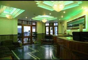 穆索里Hotel Abhinandan Mussoorie Near Mall Road - Parking Facilities & Prime Location - Best Hotel in Mussoorie的餐厅内拥有绿色墙壁和吊灯的酒吧