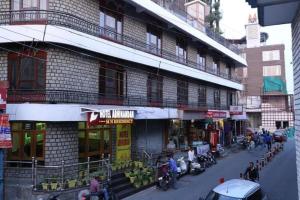 穆索里Hotel Abhinandan Mussoorie Near Mall Road - Parking Facilities & Prime Location - Best Hotel in Mussoorie的一群人站在建筑物外