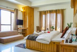 穆索里Hotel Abhinandan Mussoorie Near Mall Road - Parking Facilities & Prime Location - Best Hotel in Mussoorie的一间大卧室,配有一张大床和一张沙发