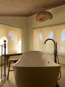 翁蒂年特Hotel Finca La Mixtura, Restaurant Mélange的带窗户的浴室设有大浴缸