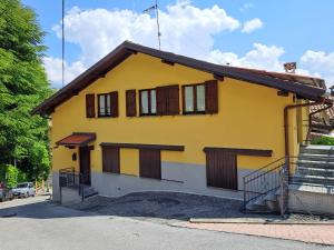 MagreglioMansardHouse zona Bellagio的黄色房子,设有棕色百叶窗