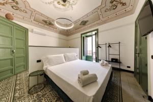 切法卢Palazzo Villelmi的卧室配有带毛巾的大型白色床