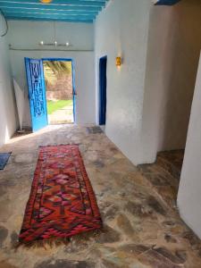 Ḩajlahمنزل حجري بحديقتين的一间有门的地板上地毯的房间