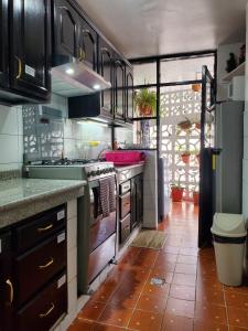 基多Apartamento 32 Juana de Arco的厨房配有水槽和炉灶