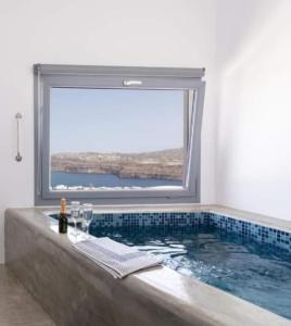 阿克罗蒂里潘珂丽珊酒店的一间带大浴缸及大窗户的浴室